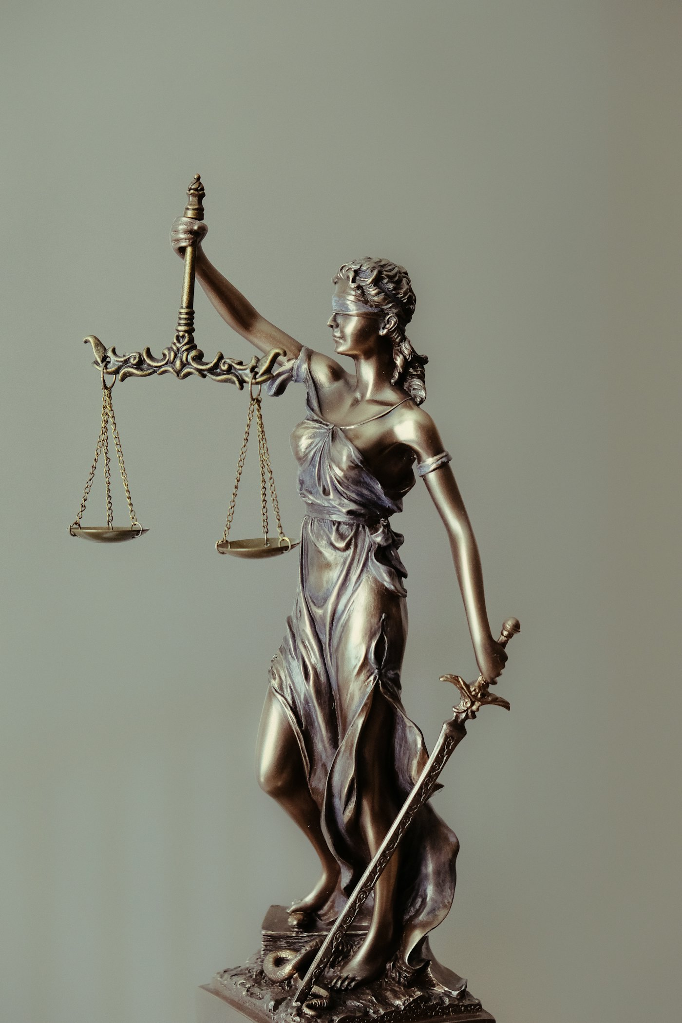 Statue of Lady Justice holding balanced scales and a sword